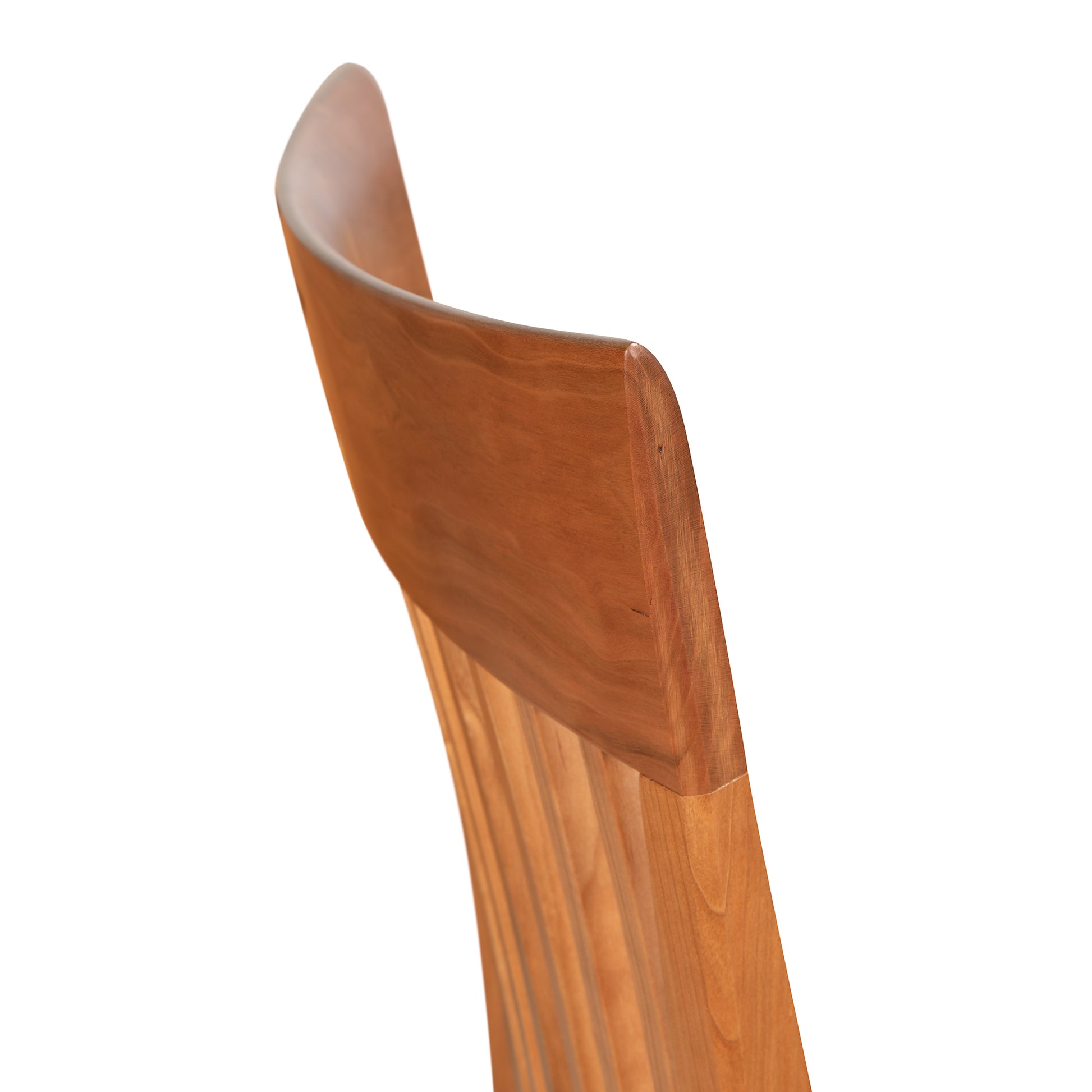 Detail of a Vermont Woods Studios Contemporary Shaker Side Chair backrest with a curved design, isolated against a white background.