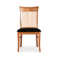 A wooden chair with a tall, slatted back and a black cushioned seat, set against a plain white background, embodies the essence of a Vermont Woods Studios Contemporary Shaker Chair.