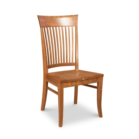A Vermont Woods Studios Contemporary Shaker Chair with Wood Seat, featuring a vertical slatted backrest and a scooped wooden seat, set against a white background. The chair also showcases slightly curved legs and a warm, natural finish.