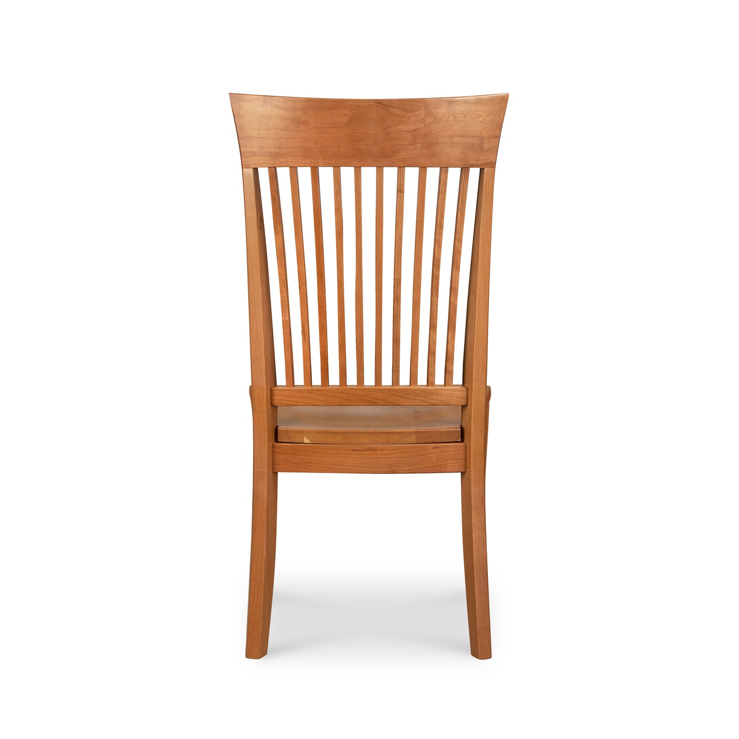 This Contemporary Shaker Side Chair with a wood seat, a display model by Vermont Woods Studios, features a natural cherry finish. Viewed from the back, it boasts a solid backrest with vertical slats and slightly curved legs. The seat appears flat and level, complemented by the horizontal slat just below it.