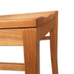 A close up of a wooden table with a wooden seat.