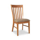 A Vermont Woods Studios Country Shaker Chair with a high, ergonomic seat back and a padded seat covered in beige upholstery, isolated on a white background.