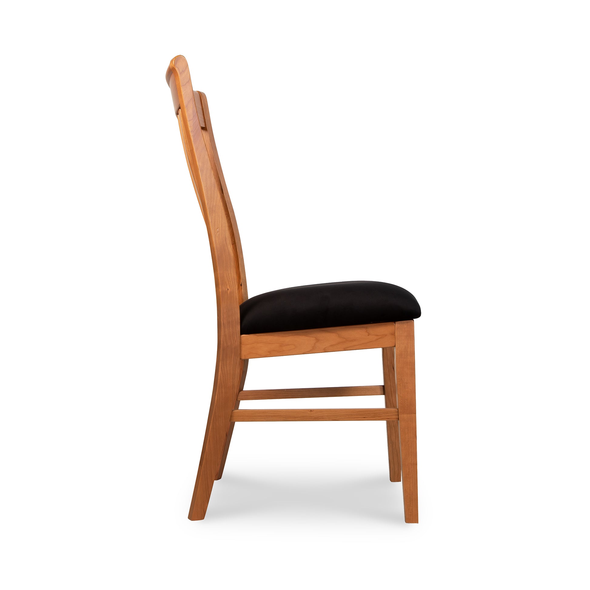 A wooden dining chair with black upholstered seat.