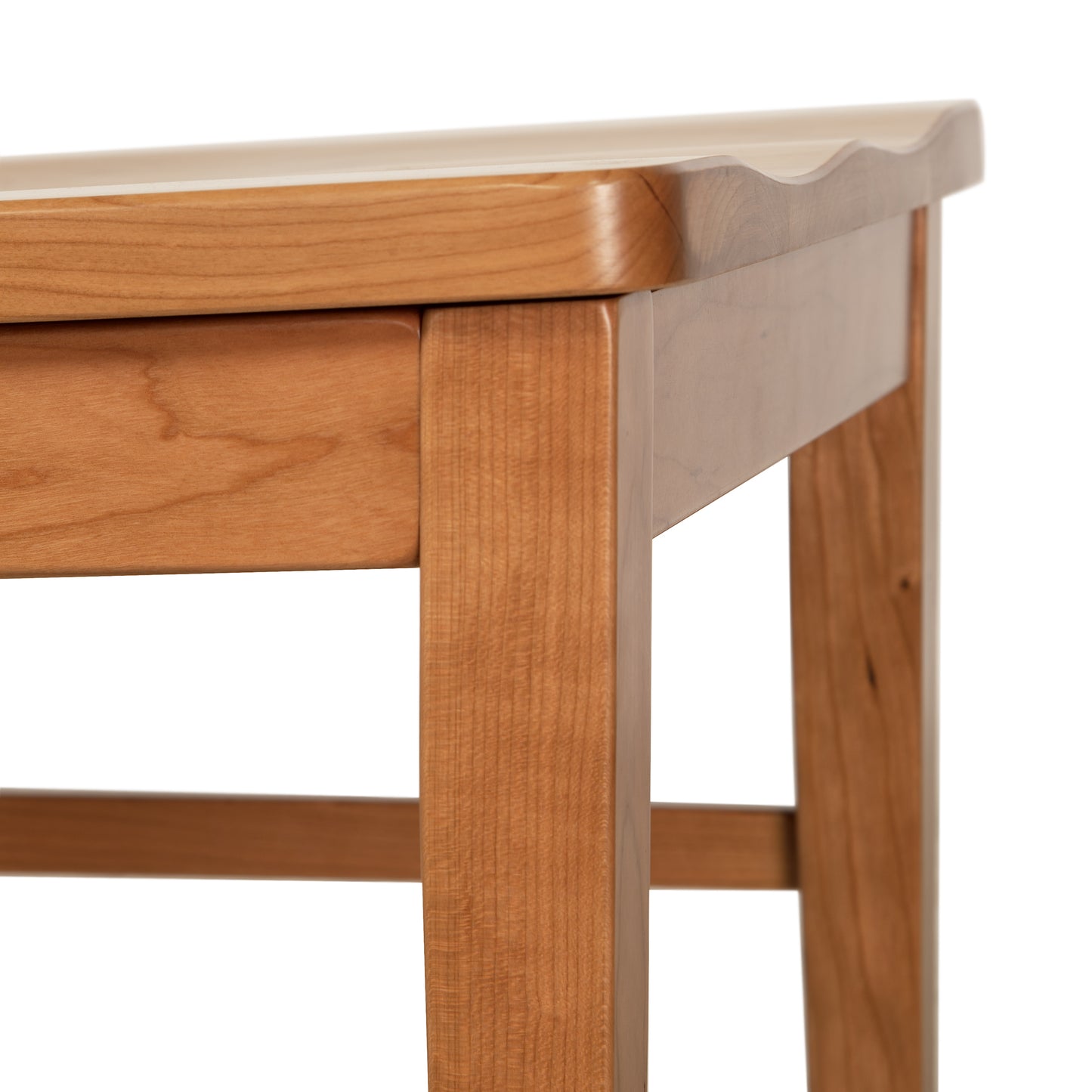 Close-up of a Vermont Woods Studios Country Shaker Chair with Wood Seat showing details of its solid wood construction and the joinery between the tabletop and leg.