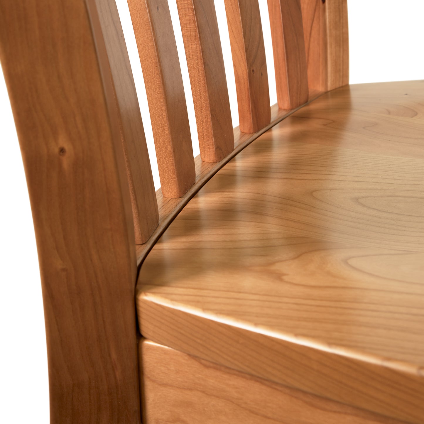 Close-up of a Vermont Woods Studios Country Shaker Chair with Wood Seat with a slatted back and a smooth, curved seat, highlighting the grain and natural finish of the wood.