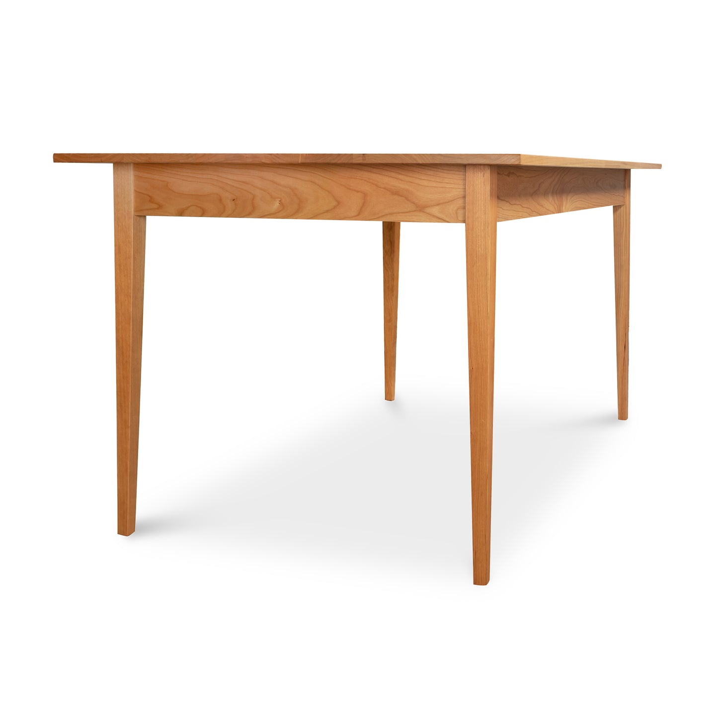 A traditional Vermont Woods Studios Country Shaker Dining Table featuring natural wood grain.