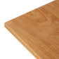 A close up of a Vermont Woods Studios Country Shaker Dining Table with natural wood grain.