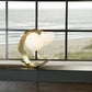 Hubbardton Forge Crest Table Lamp with sculptural design and globe-shaped glass shade.