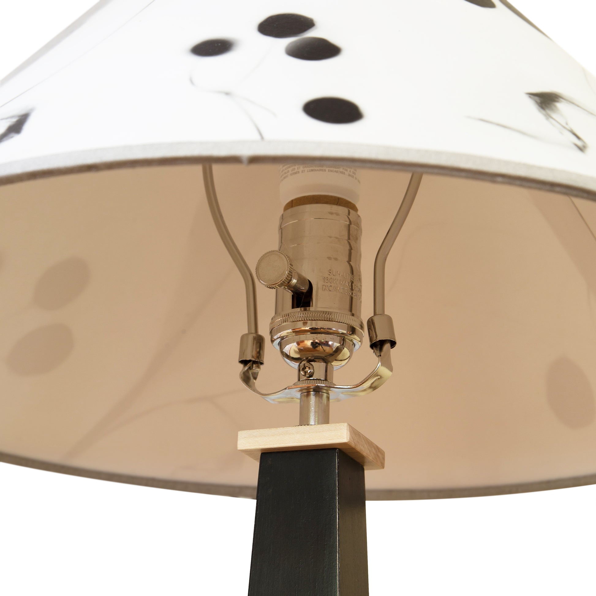Rock River Studio Dance of Life Table Lamp showcasing its detailed socket, harp, and uniquely patterned white shade with black accents.