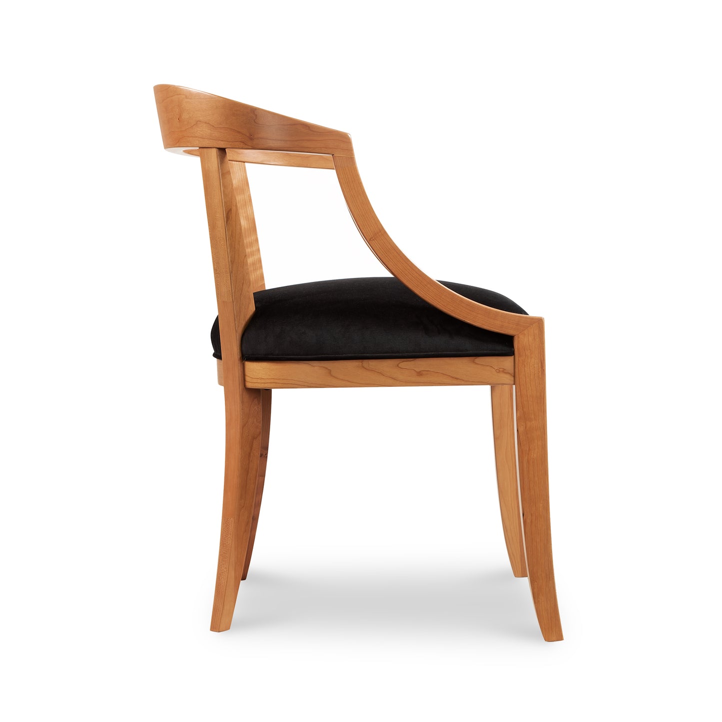 A wooden chair with black velvet upholstered seat.