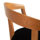 Close-up of the curved wooden backrest and arm of a Vermont Woods Studios Dorset Chair with a black upholstered seat, against a white background.