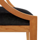 A close up of a chair with black velvet upholstered seat.