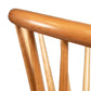 Close-up of the Dover Curveback Windsor Chair - Display Model from Vermont Woods Studios backrest, showcasing its vertical slats and rounded top rail. This eco-friendly solid wood chair has a smooth finish with a natural light brown hue, combining style with an ergonomic seat back.