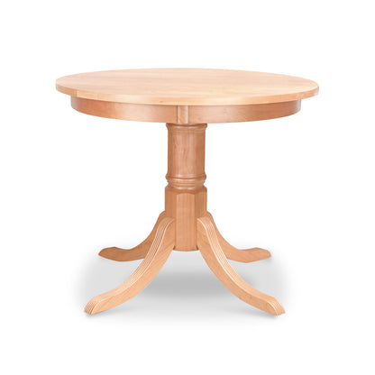 Solid wood Lyndon Furniture Duncan-Phyfe Round Pedestal Dining Table with light natural finish. American made dining table features smooth solid top and central pedestal base with four curved legs. High quality Vermont made furniture piece against white background.