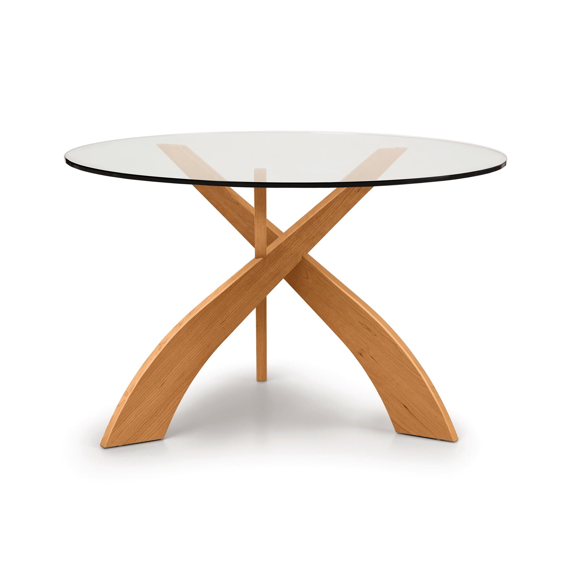 A dining table with a glass top and wooden legs.