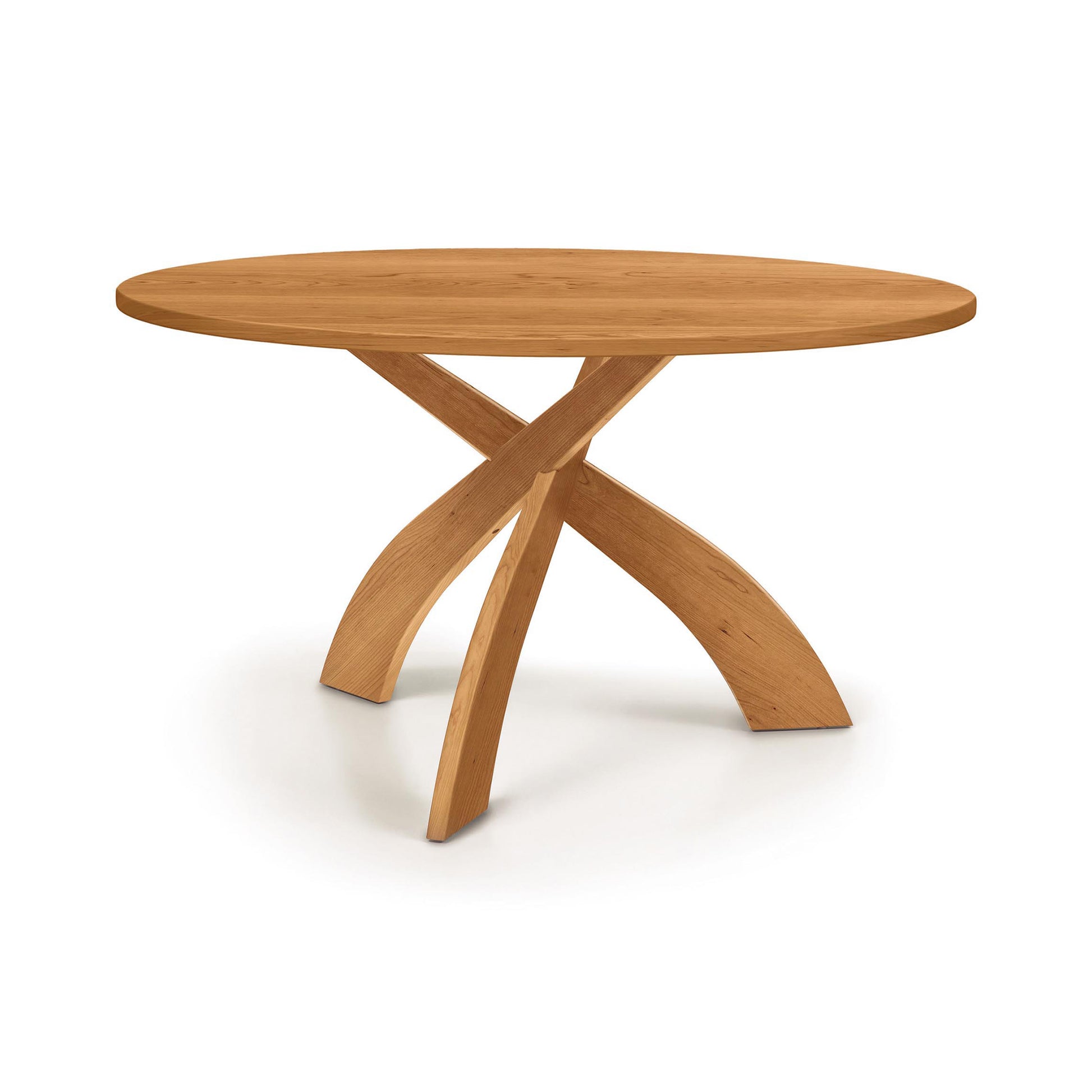 Entwine Round Solid Top Table by Copeland Furniture showcases cherry wood and unique intersecting curved legs, highlighting its American craftsmanship.