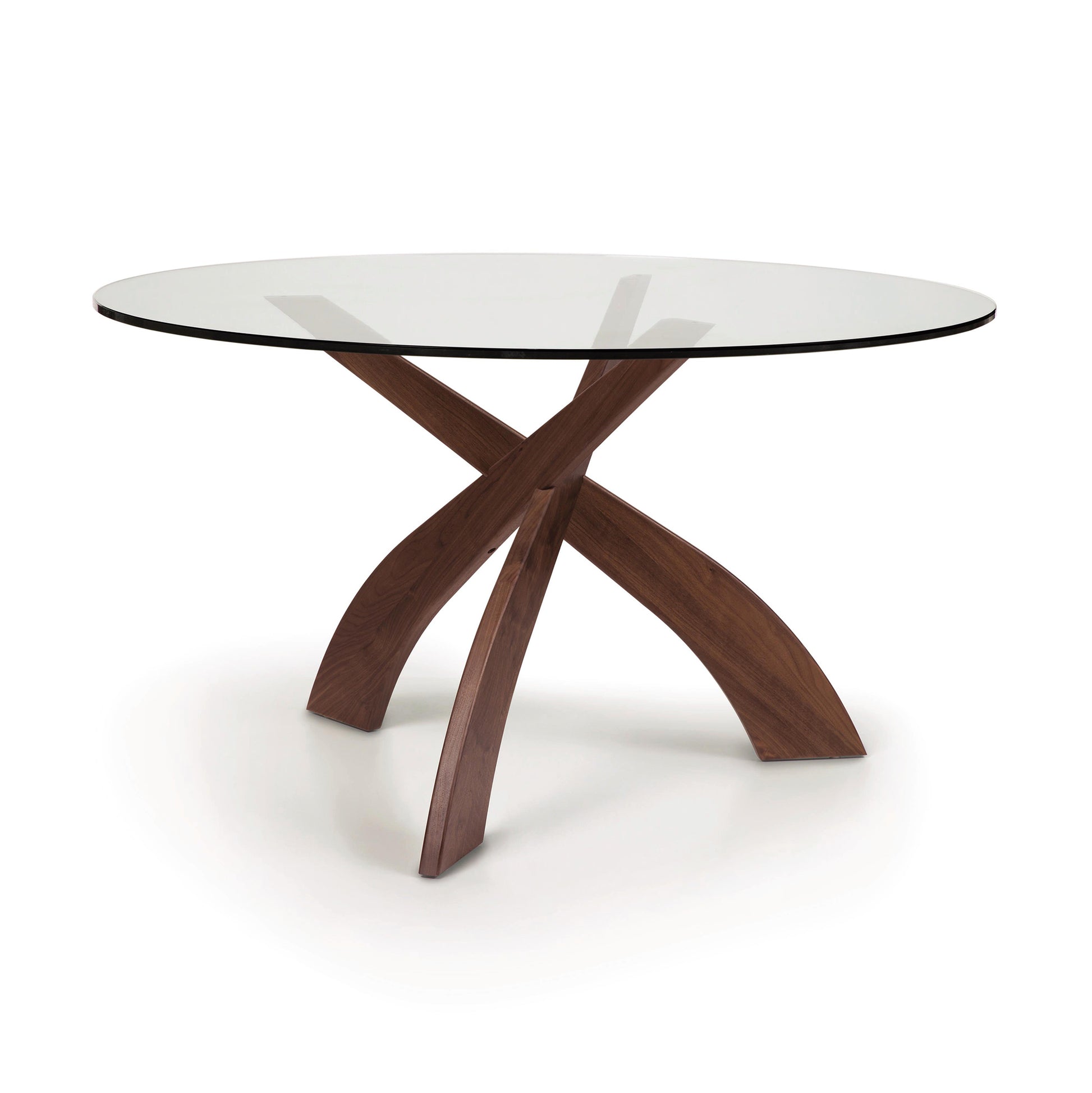 Entwine Round Glass Top Dining Table by Copeland Furniture with a tempered glass top and a sustainably sourced cherry wood cross-shaped base on a white background.