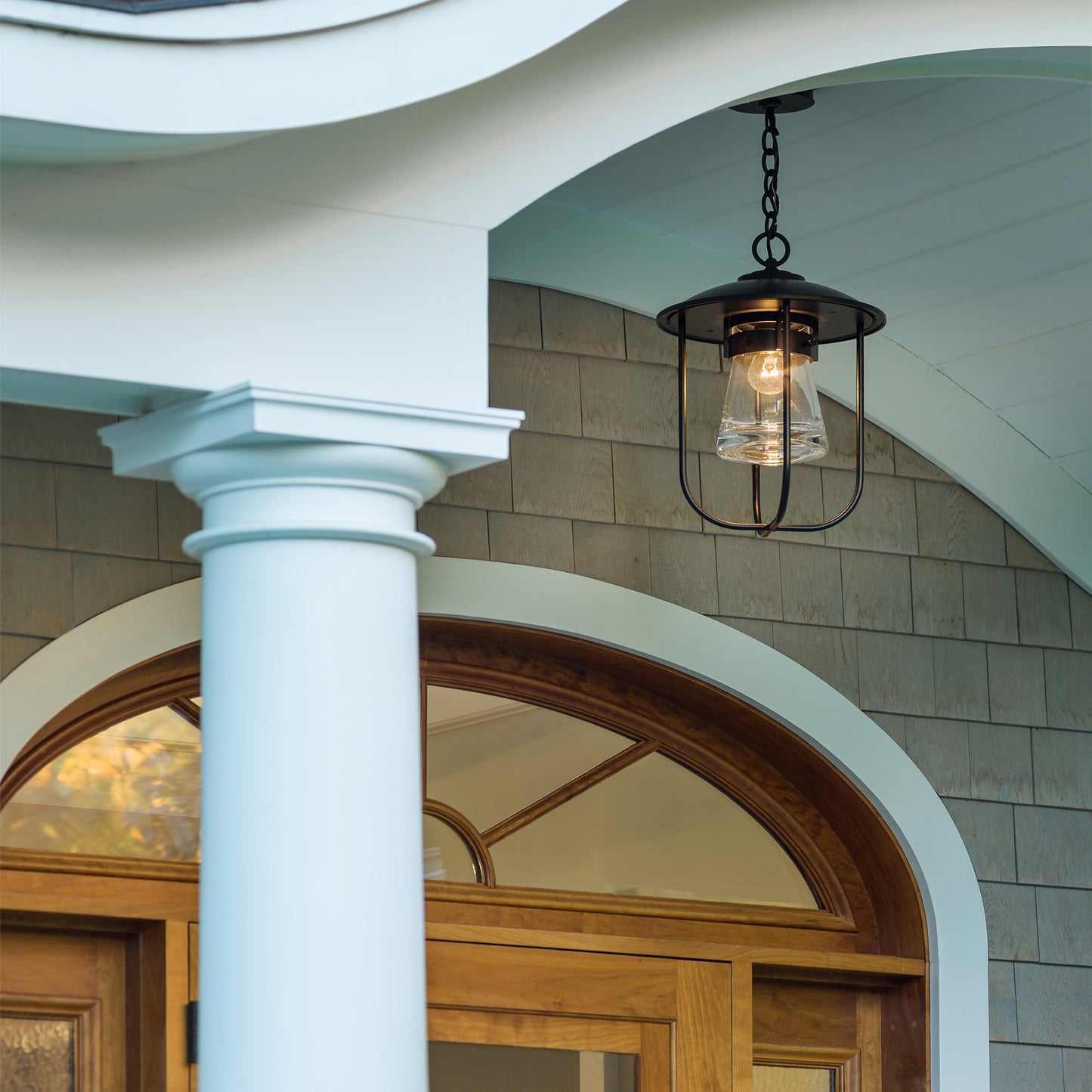 Close-up of the Hubbardton Forge Erlenmeyer Outdoor Pendant, a high-quality, American-made lighting fixture on a porch.