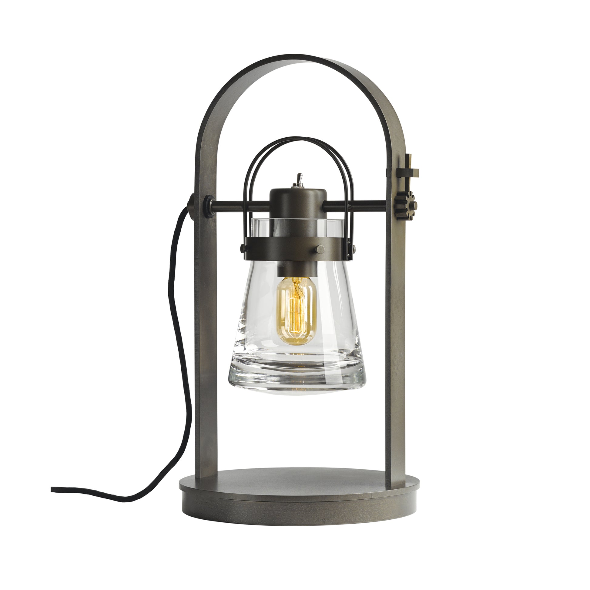 The Hubbardton Forge Erlenmeyer Table Lamp, designed with a steampunk twist, features a metal base and a glass shade.