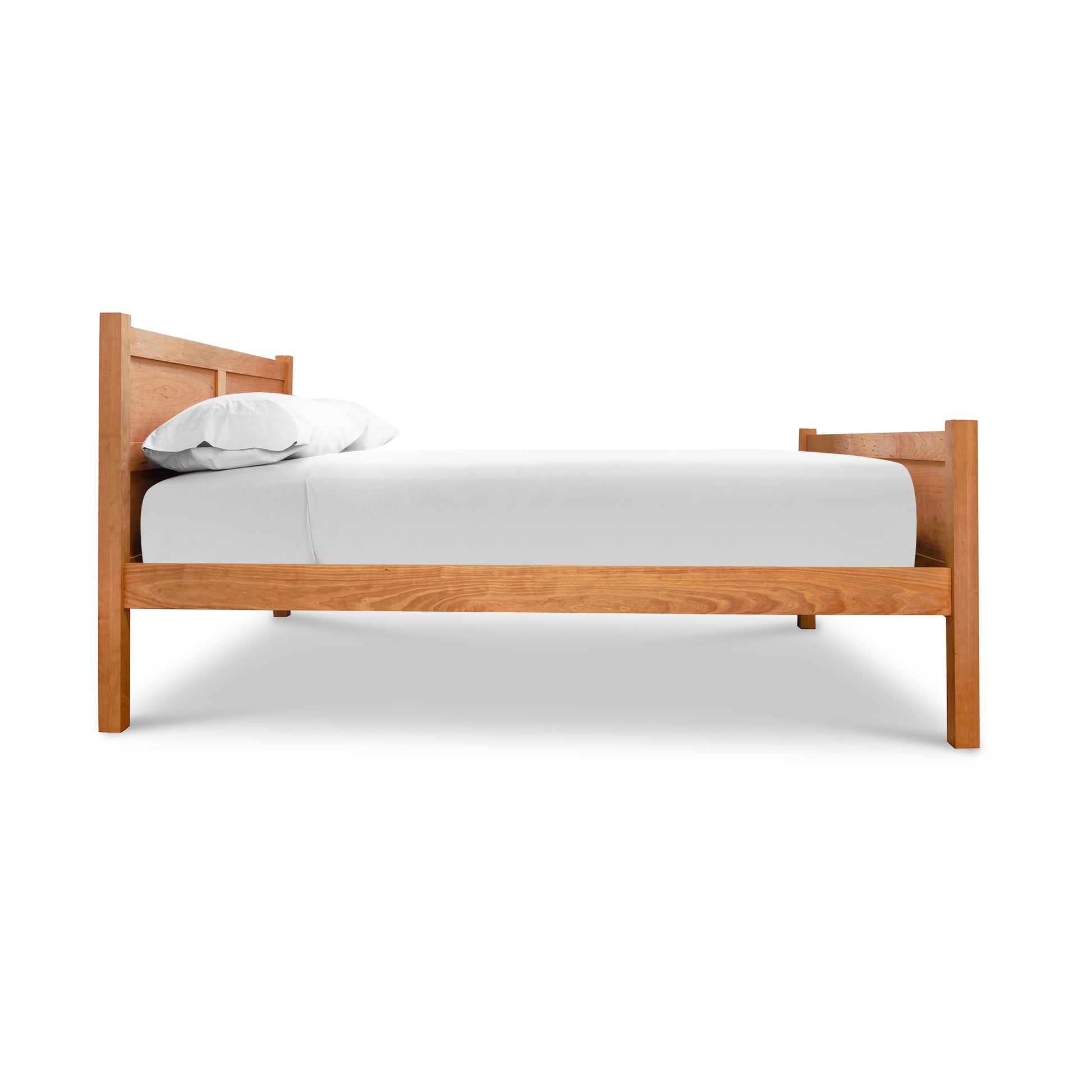 Essex High Footboard Bed by Vermont Furniture Designs, featuring classic wood craftsmanship with a white mattress and pillows, side view.