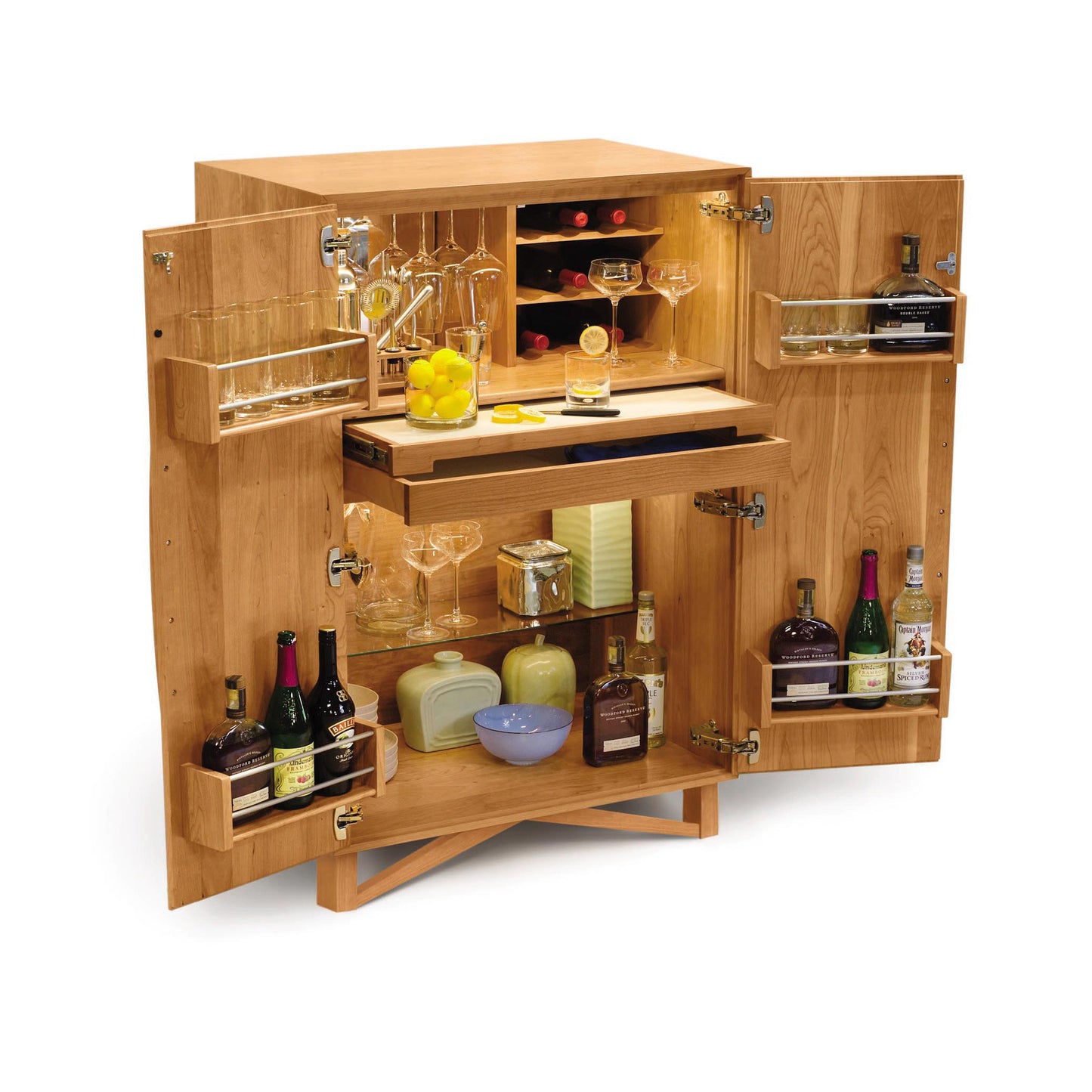 A Copeland Furniture Exeter Bar Cabinet designed as a mid-century modern home bar, with doors open to reveal shelves stocked with various bottles of spirits, glasses, and bar accessories.