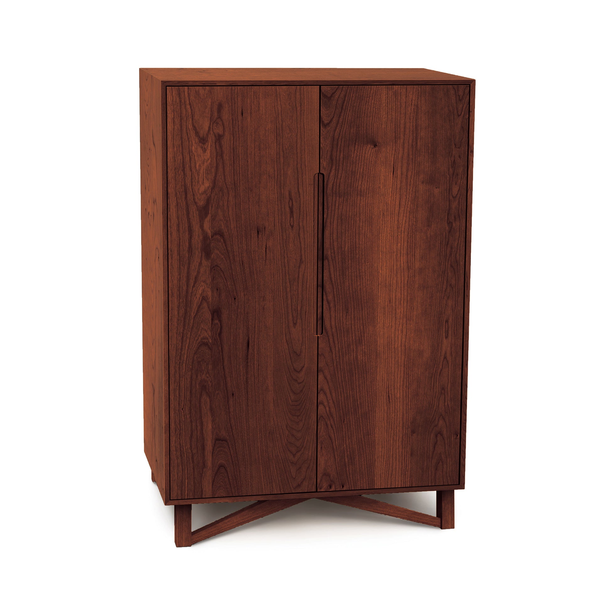 A Copeland Furniture Exeter Bar Cabinet with closed double doors, positioned on angled legs and isolated on a white background.