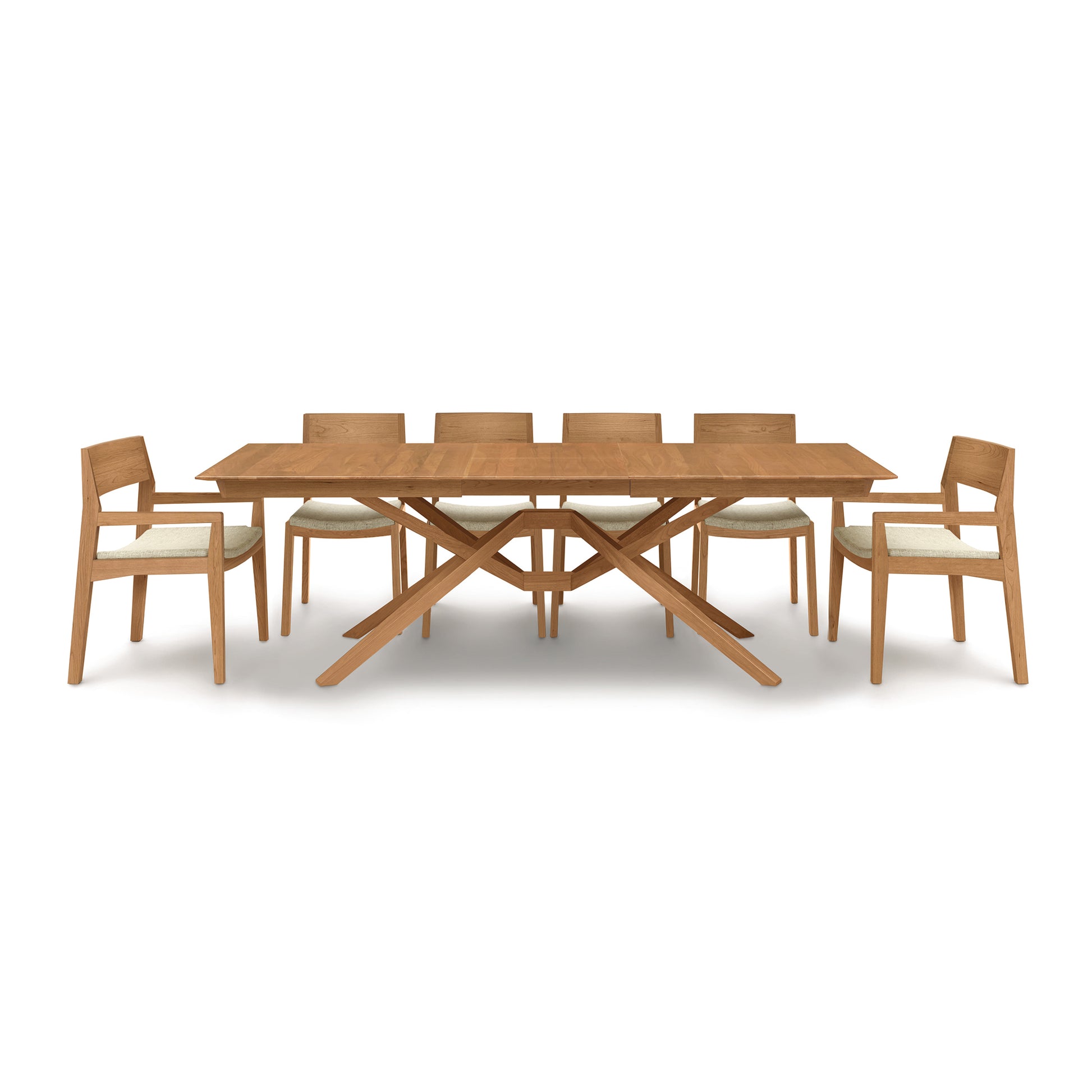 Exeter Extension Dining Table by Copeland Furniture featuring a distinctive wooden X-shaped base, complemented by six cushioned chairs and a convenient butterfly leaf extension.