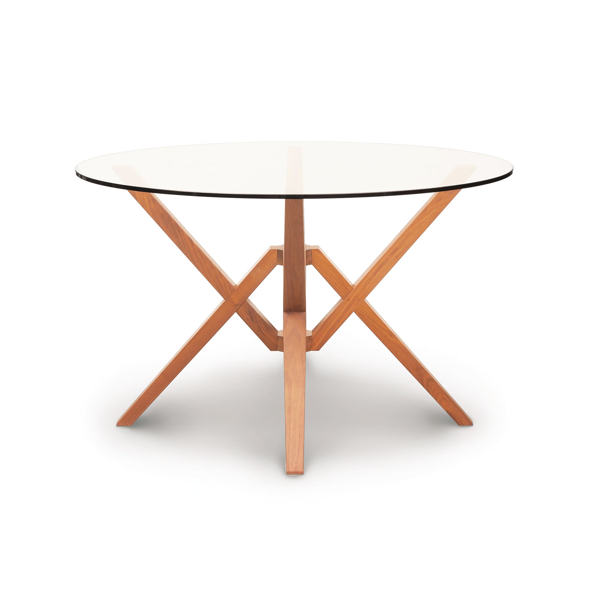 The Copeland Furniture Exeter Round Glass Top Table features an innovative isometric design with wooden legs and a glass top.
