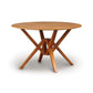 A wooden Copeland Furniture Exeter Round Solid Top Dining Table with crossing legs on a white background, crafted from sustainably harvested hardwoods.