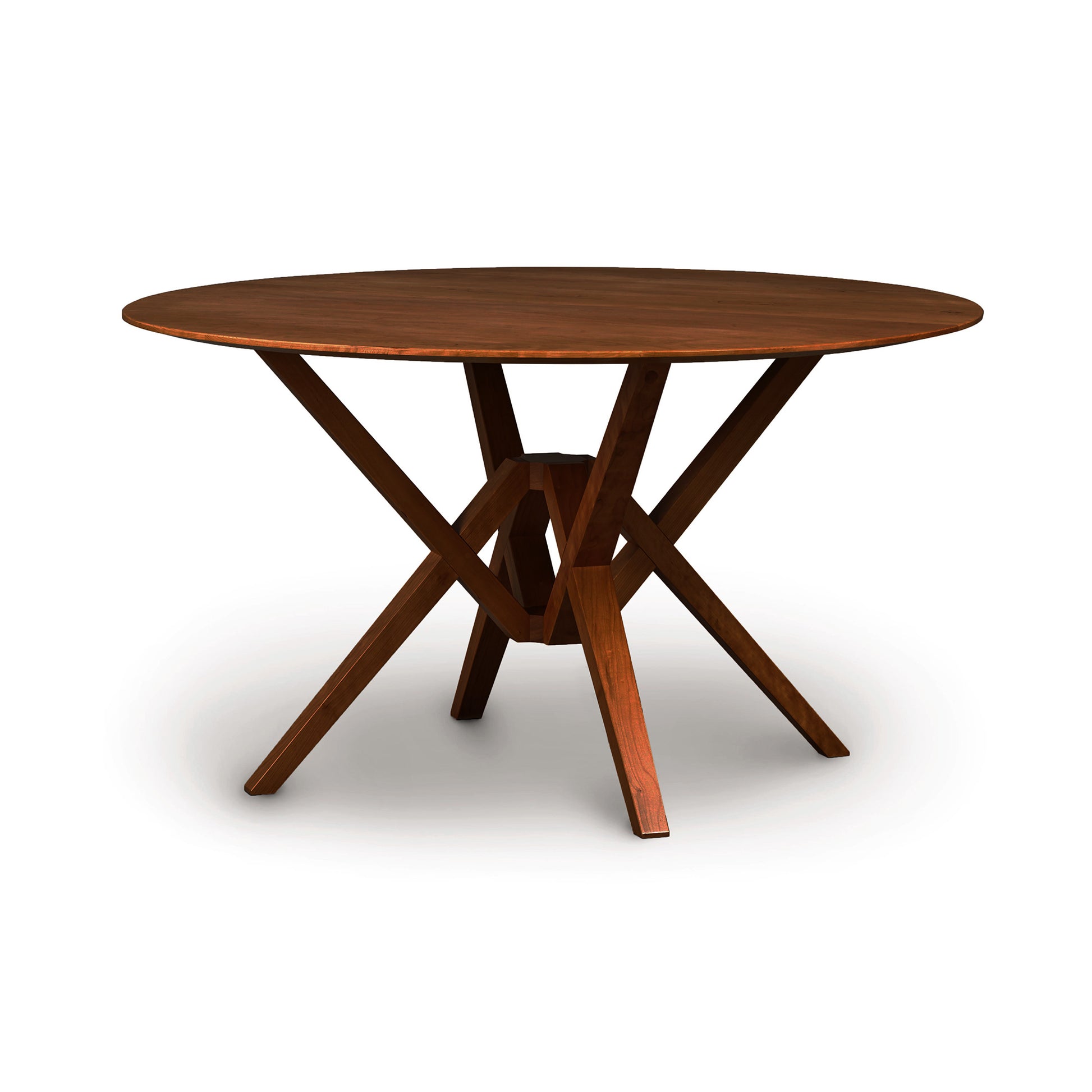 A sustainably harvested hardwood Exeter Round Solid Top Dining Table by Copeland Furniture with a cross-leg support design, isolated on a white background.