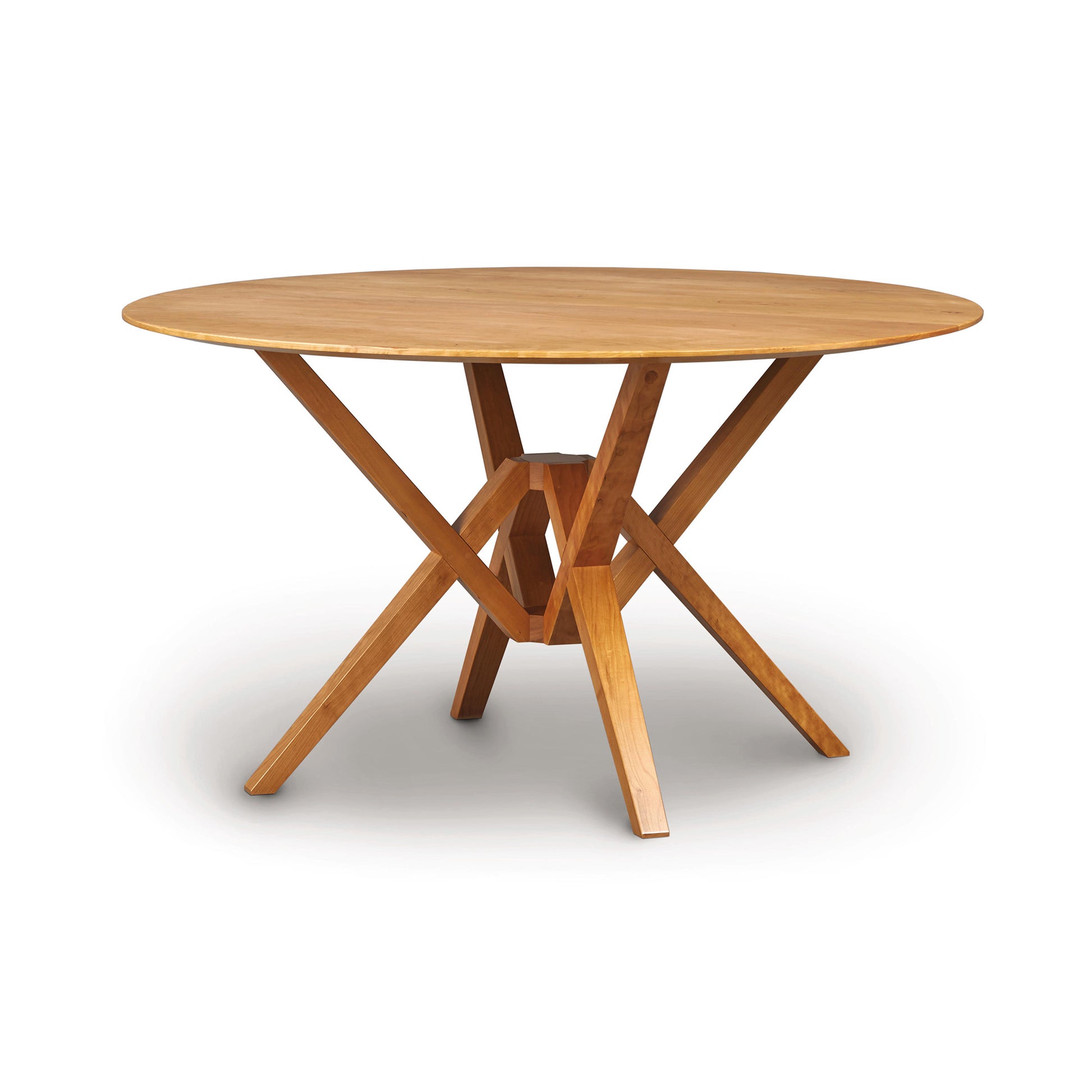 A round Copeland Furniture Exeter Round Solid Top Dining Table with an x-shaped base, isolated on a white background.