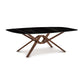 Rectangular Exeter Sintered Stone Top Table by Copeland Furniture, featuring a glossy black surface and distinctive intersecting wooden legs.