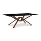 Exeter table by Copeland Furniture featuring a black stone top and intricately carved hardwood legs.