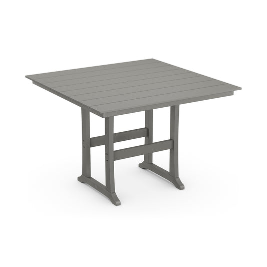 A 3D rendering of a POLYWOOD Farmhouse Trestle 59" Bar Table with a grey slatted top made of POLYWOOD® lumber and a sturdy metallic frame. The table appears durable and is designed for outdoor use.