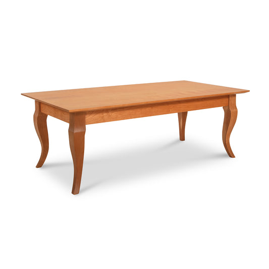 This French Country Coffee Table by Lyndon Furniture is a handmade, rectangular solid wood table featuring four curvaceous legs. Crafted in Vermont from sustainably harvested hardwoods, this light-colored coffee table has a smooth surface and showcases a classic design, perfect for American made furniture enthusiasts.