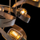 A Hubbardton Forge Graffiti Pendant adorned with graffiti painting, featuring a multitude of light bulbs illuminating the chandelier.