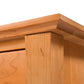 A close up of the top of a wooden Lyndon Furniture Green Mountain 3-Drawer Nightstand.
