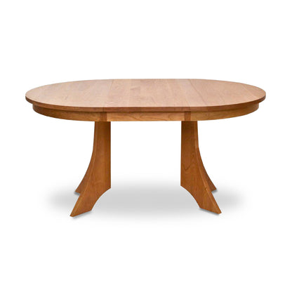 American made solid wood Hampton Split Pedestal Extension Table by Lyndon Furniture. This handcrafted cherry or walnut dining table features an oval top, a light-colored smooth finish, and a central pedestal base with two curved supports. High-quality Vermont made furniture ideal for any luxury dining room setting, displayed against a white background.