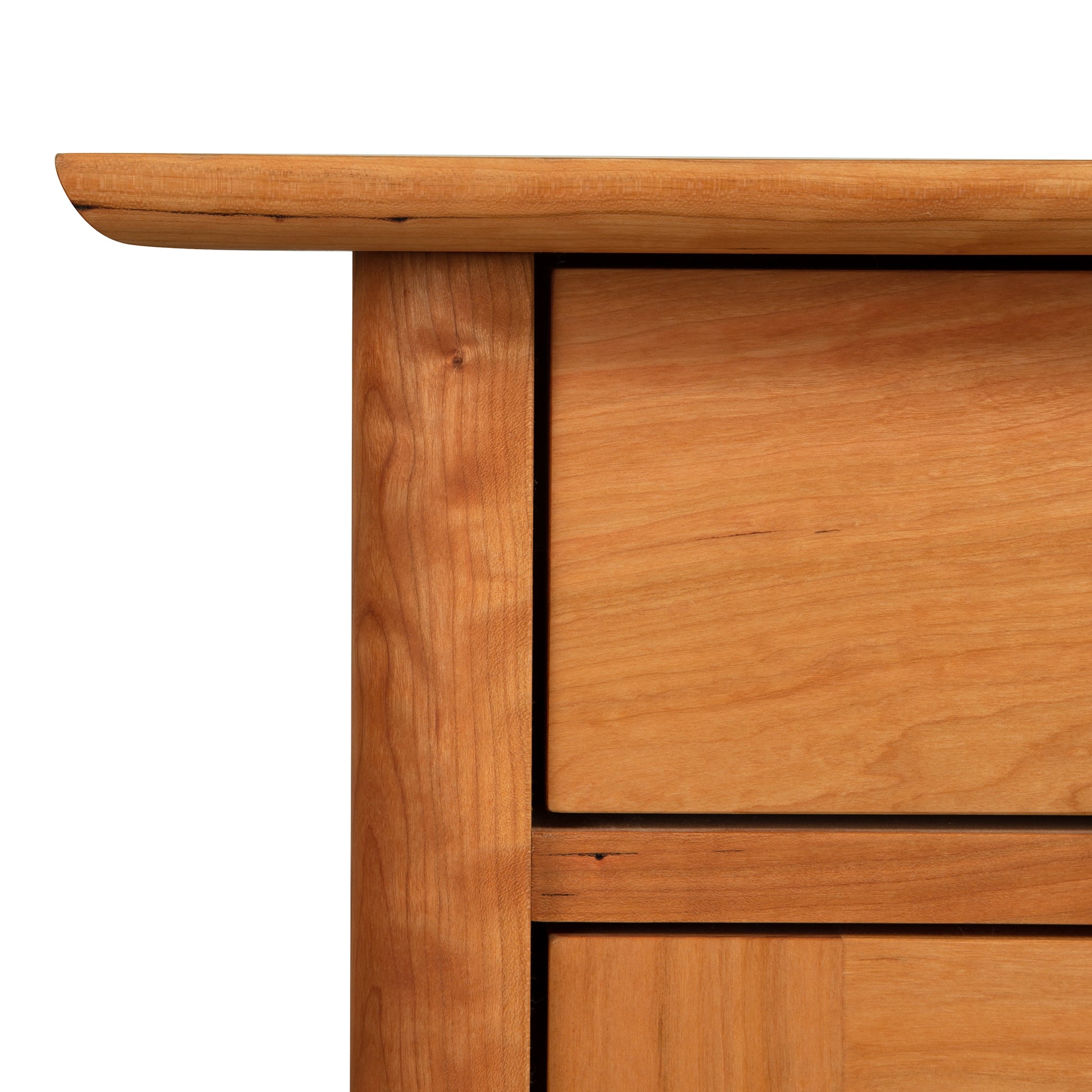 Close-up of a Vermont Furniture Designs Heartwood Shaker 1-Drawer Nightstand with Door corner showing the wood grain and joinery details against a white background.