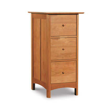 A solid wood three-drawer vertical filing cabinet in the Heartwood Shaker style by Vermont Furniture Designs isolated on a white background.