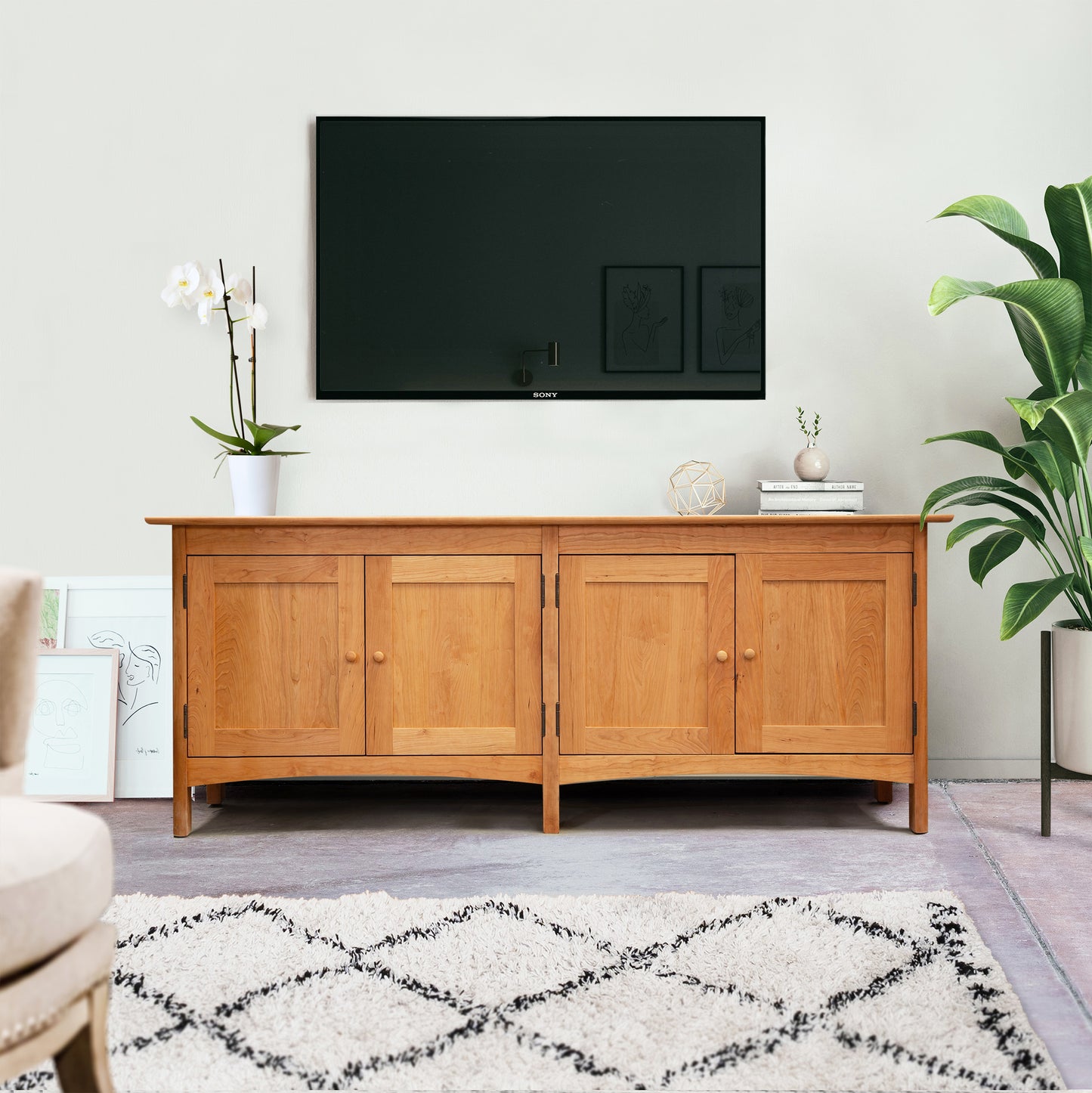 Heartwood Shaker 4-Door Console Bookcase by Vermont Furniture Designs, handcrafted in Vermont from solid wood, showcased beneath a wall-mounted TV.