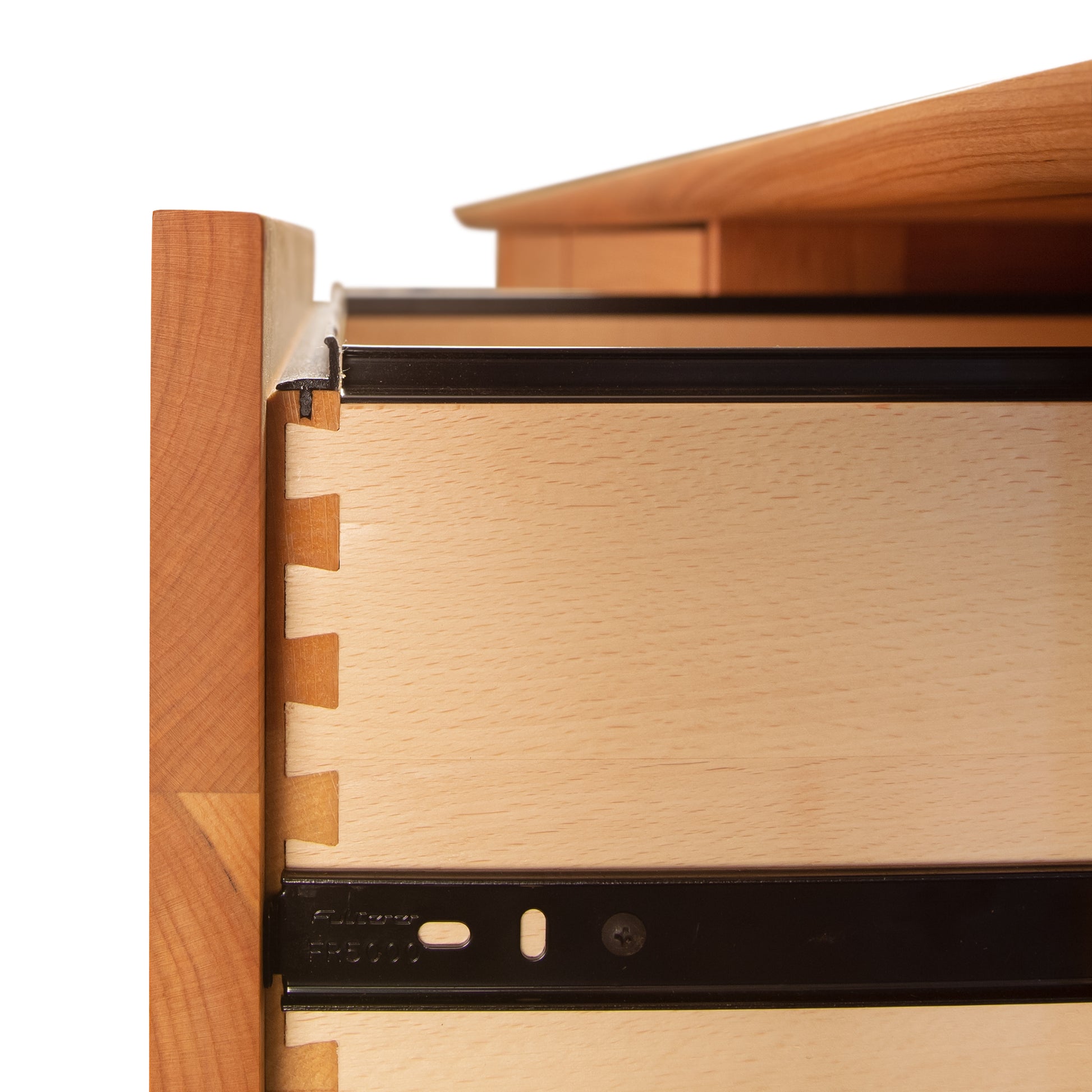 Close-up of a Vermont Furniture Designs Heartwood Shaker 6-Drawer Legal File Cabinet with dovetail joints, partially open to reveal a legal size file hanger frame inside.