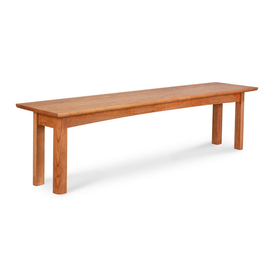 A Heartwood Shaker Bench from Vermont Furniture Designs, with a straightforward design featuring a flat top and four legs, against a white background.