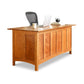 A high-end Heartwood Shaker Executive Desk by Vermont Furniture Designs with a laptop on top.