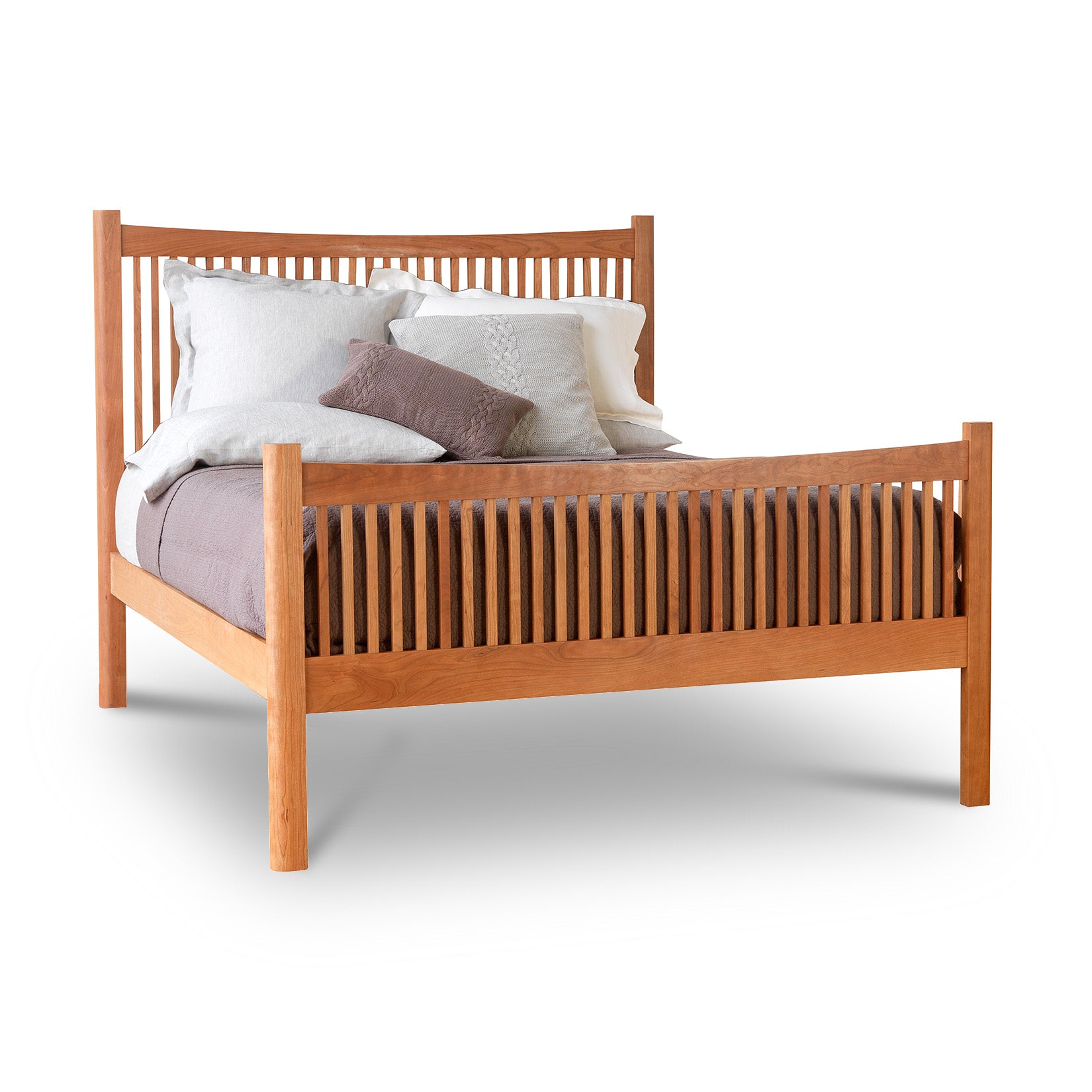 A Vermont Furniture Designs Heartwood Shaker High Footboard Bed with a slatted headboard and footboard, fitted with white and brown pillows, isolated on a white background.