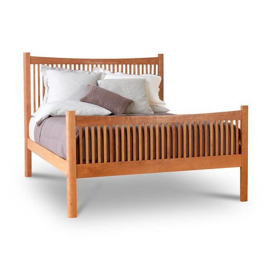 A Vermont Furniture Designs Heartwood Shaker High Footboard Bed with a slatted headboard and footboard, fitted with white and brown pillows, isolated on a white background.