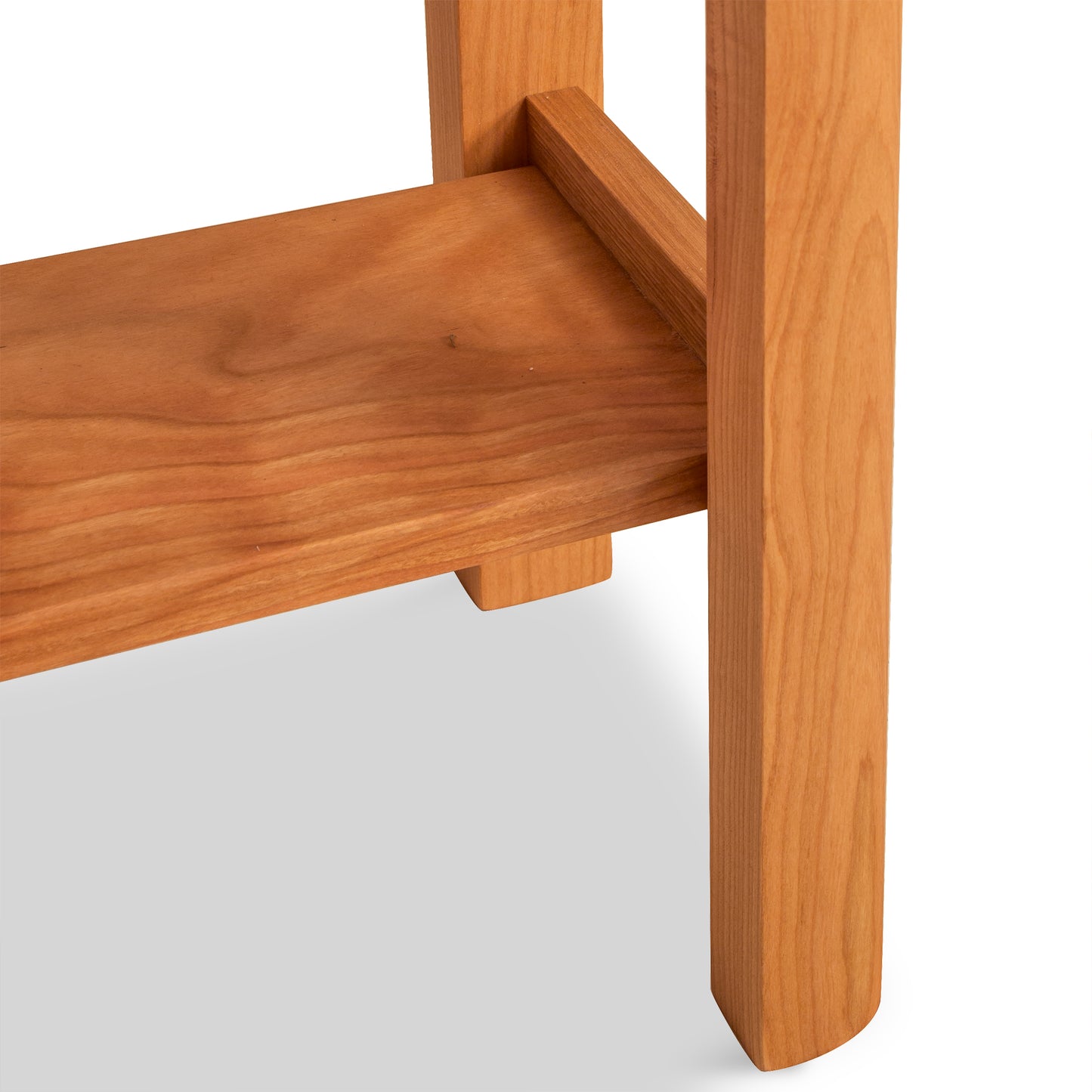 Close-up of a Vermont Furniture Designs Heartwood Shaker End Table leg and seat junction showing the wood grain and eco-friendly oil finish construction detail.