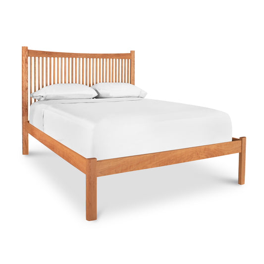 A Heartwood Shaker Low Footboard Bed by Vermont Furniture Designs with a slatted headboard and a plain footboard, featuring white bedding with two pillows, isolated on a white background.
