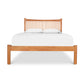 The Vermont Furniture Designs Heartwood Shaker Low Footboard Bed blends Arts and Crafts styling with the cozy comfort of white sheets, creating a stunning piece of wooden furniture.