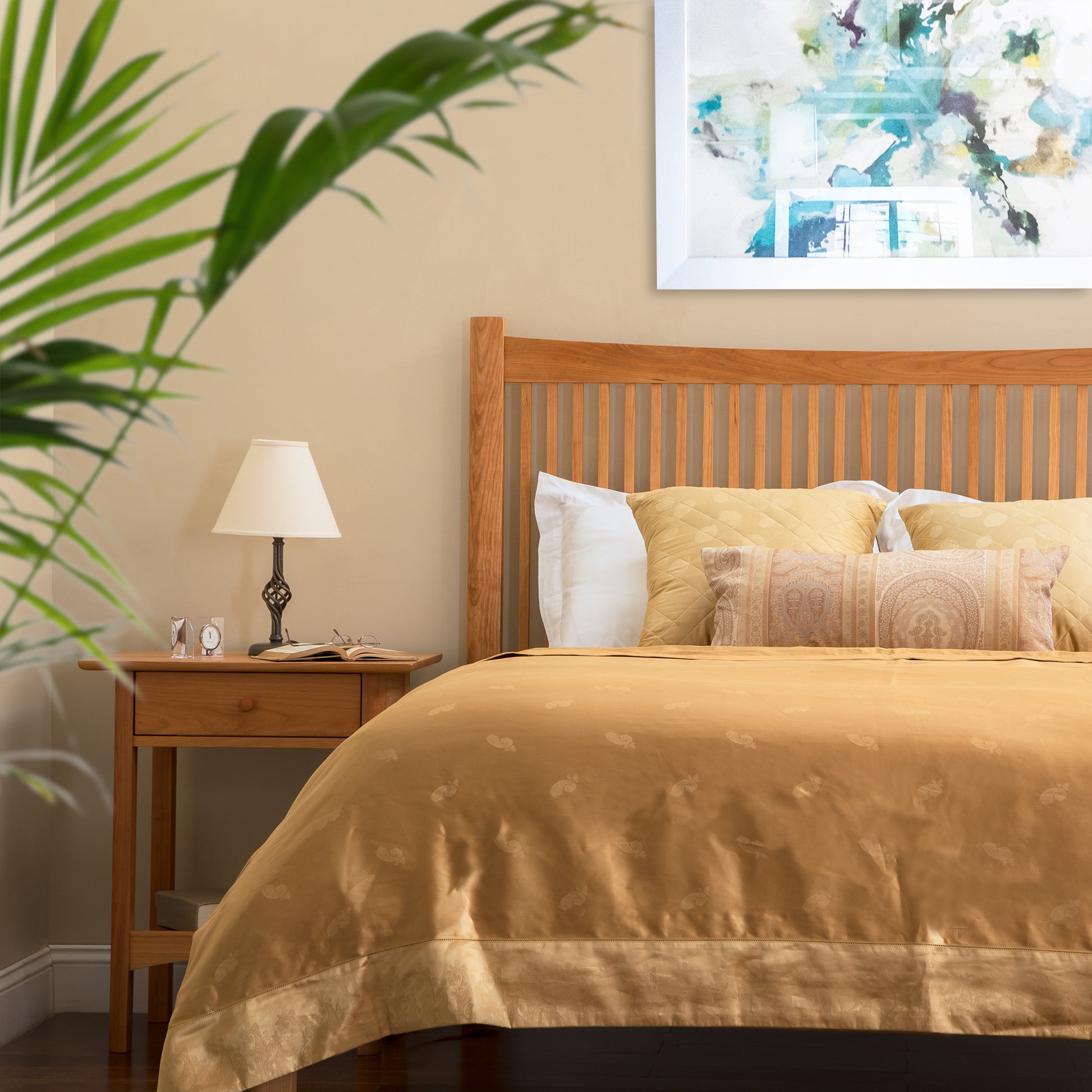 Heartwood Shaker Low Footboard Bed by Vermont Furniture Designs with gold bedding, paired with a matching wooden nightstand.
